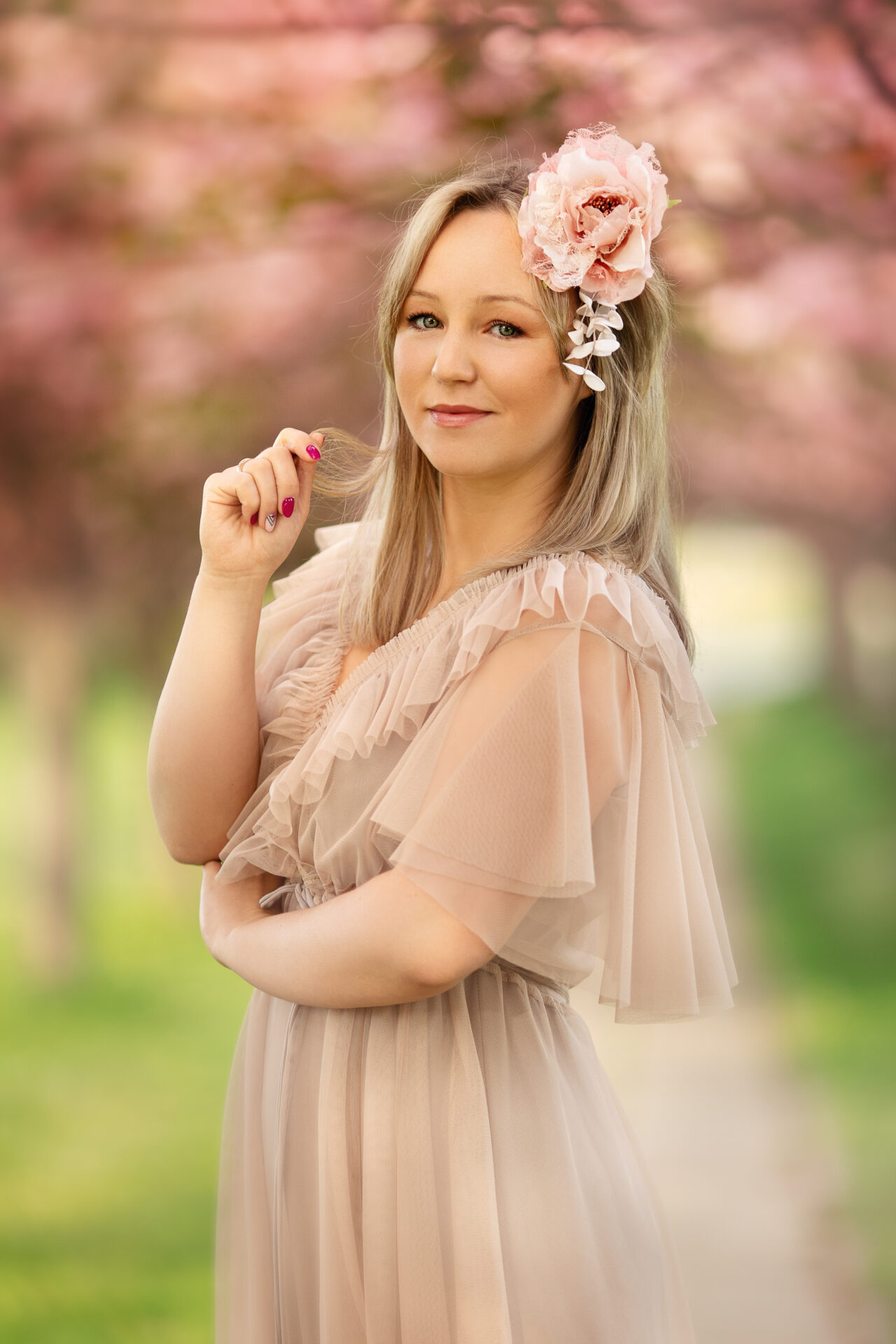 Wiosenny portret kobiety z kwiatem we włosach, wiśniowa alejka, sesja plenerowa Kraków Bronowice