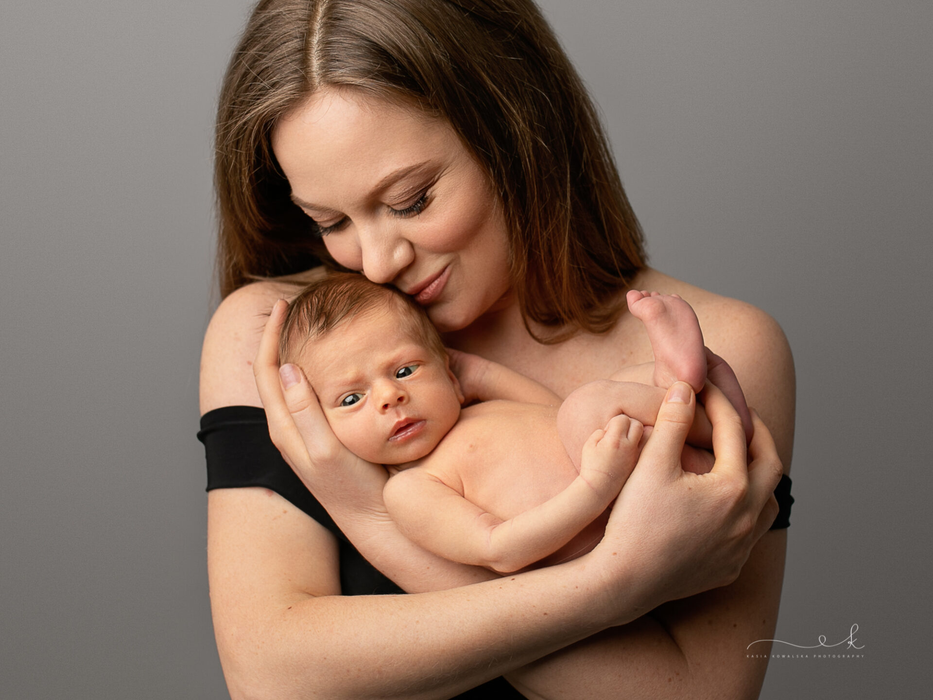 szczęśliwa mama czule tuli swoje ukochane parodniowe dziecko, portret