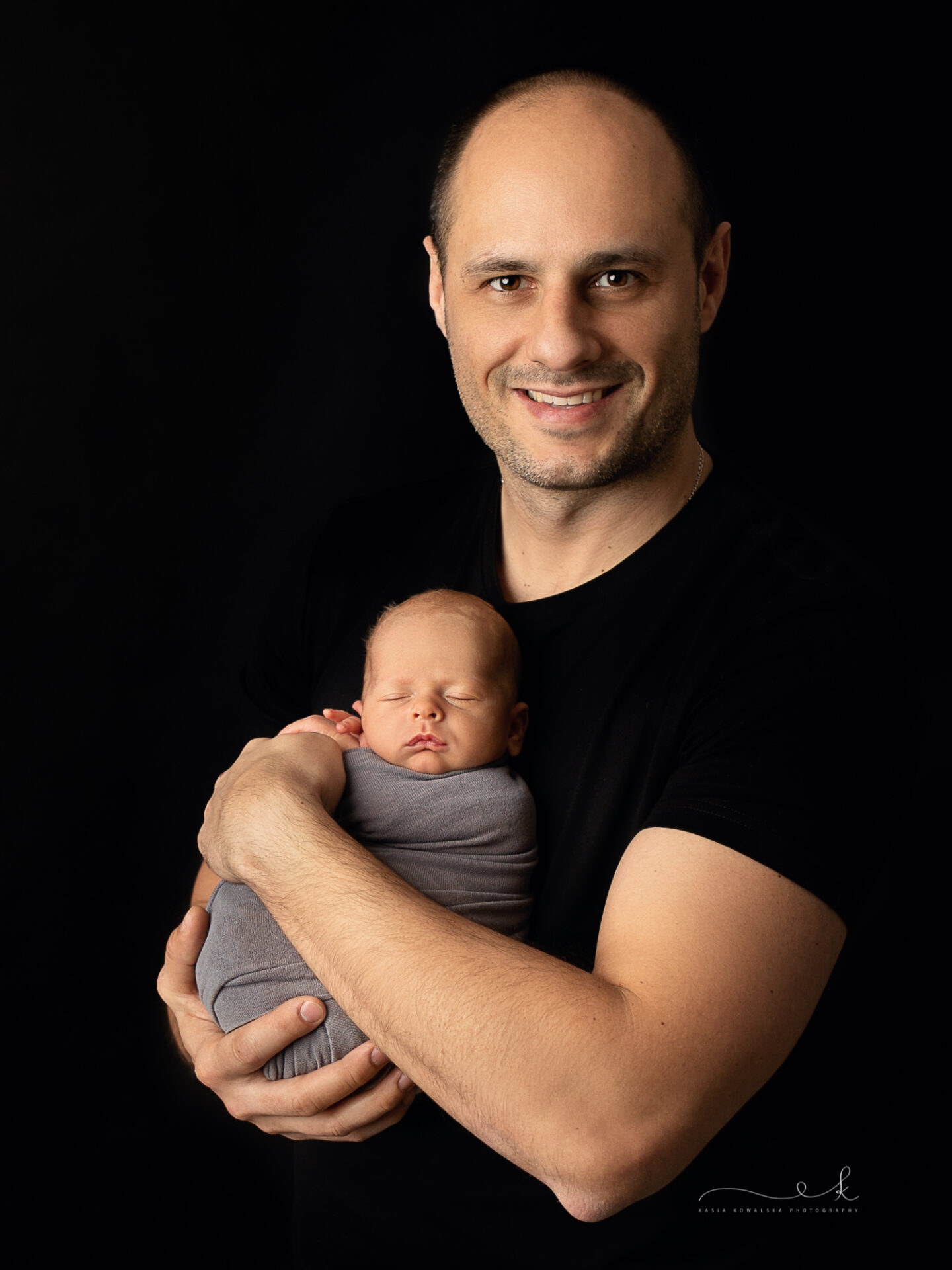 Portret taty z noworodkiem w ramionach - sesja w Krakowie