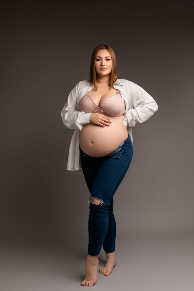 sesja ciążowa w studio, kobieta w jeansach i koszuli