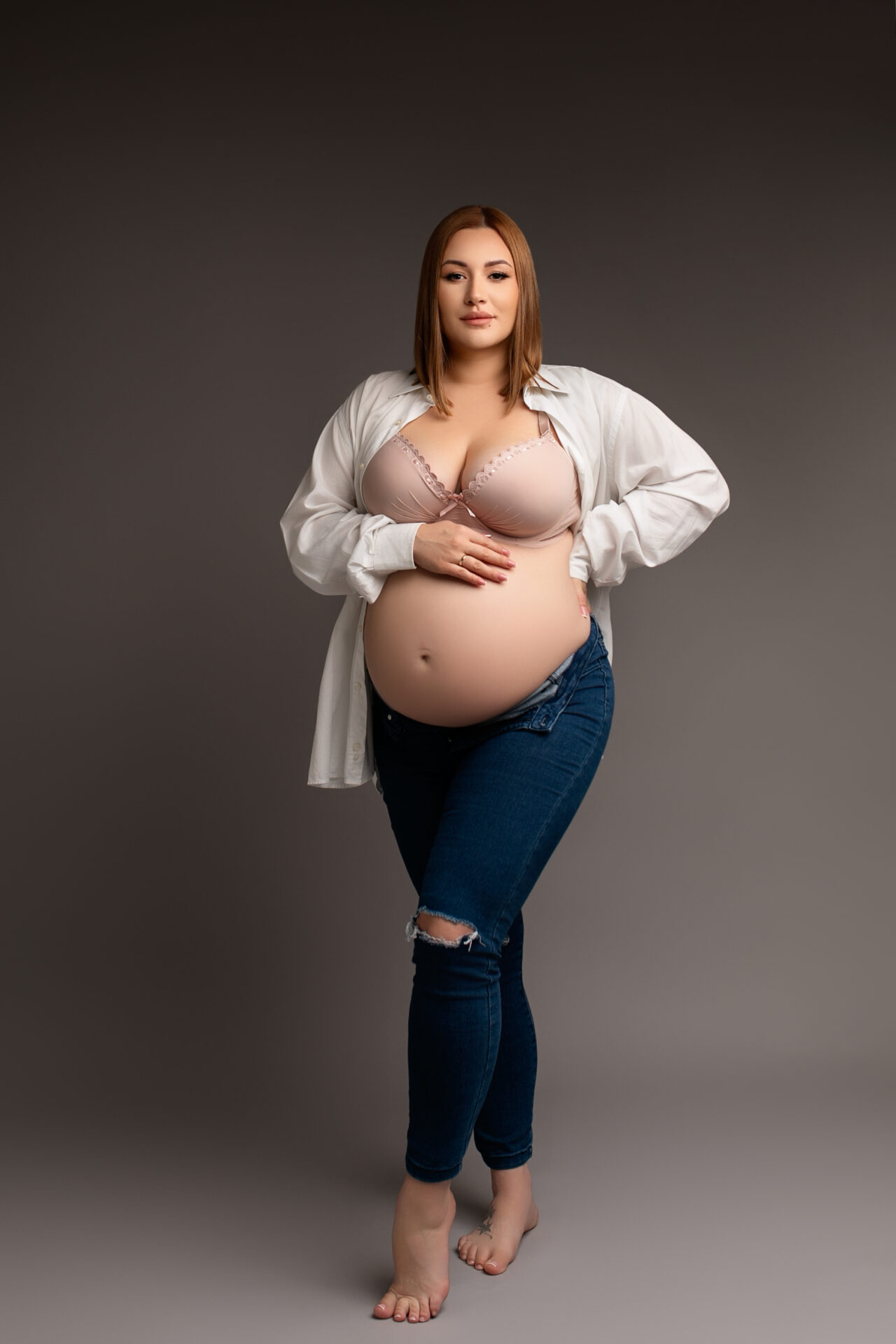 sesja ciążowa w studio, kobieta w jeansach i koszuli